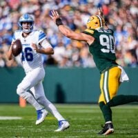 Detroit Lions quarterback Jared Goff (16) looks to pass against Green Bay Packers defensive end Lukas Van Ness (90) during the first half at Lambeau Field in Green Bay, Wis., on Sunday, September 7, 2025.