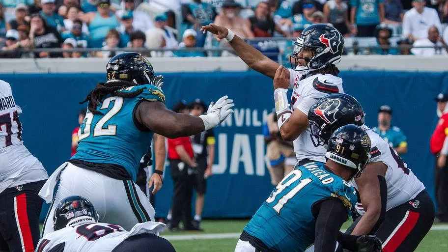 Houston Texans quarterback CJ. Stroud (7) passes under pressure by Jacksonville Jaguars defensive tackle Davon Hamilton (52) 