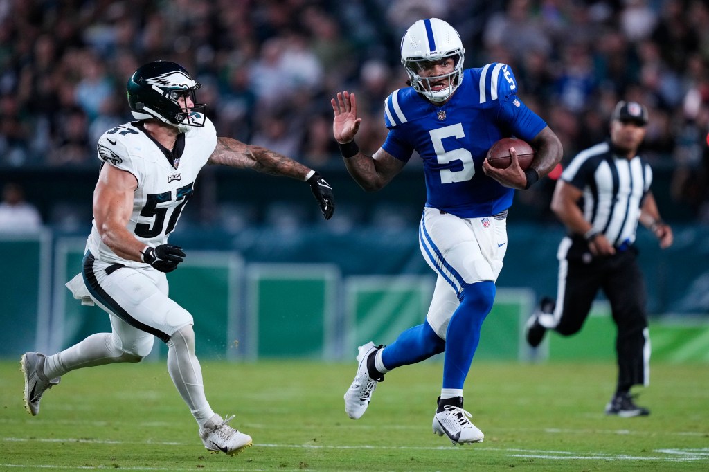 Indianapolis Colts quarterback Anthony Richardson runs with the ball under pressure from Philadelphia Eagles linebacker Ben VanSumeren.
