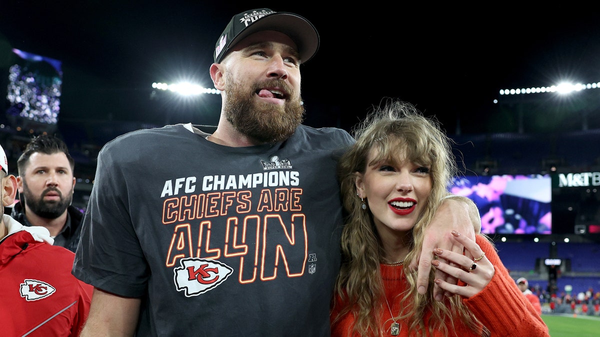 Travis Kelce celebrating with Taylor Swift on the football field at M&T Bank Stadium