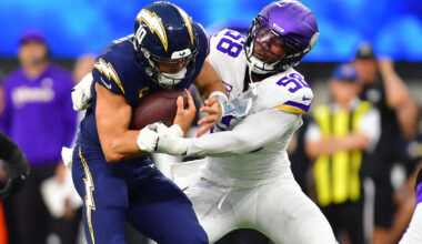 Los Angeles Chargers quarterback Justin Herbert (10) ruses the ball against Minnesota Vikings linebacker Jonathan Greenard (58) during the first half at SoFi Stadium.