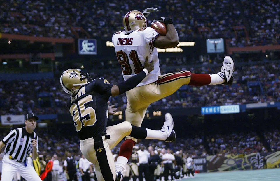 NEW ORLEANS - OCTOBER 20: Wide receiver Terrell Owens #81 of the San Francisco 49ers completes a touchdown catch while defended by Fakhir Brown #35 of the New Orleans Saints during the NFL game at the Louisiana Superdome in New Orleans, Louisiana on October 20, 2002. The Saints defeated the Niners 35-27. (Photo by Ronald Martinez /Getty Images)