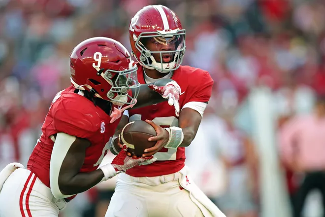 TUSCALOOSA, ALABAMA - NOVEMBER 22: Keelon Russell #12 of the Alabama Crimson Tide reads the defense before handing the ball off to Richard Young #9 during the fourth quarter of the against the Eastern Illinois Panthers at Bryant-Denny Stadium on November 22, 2025 in Tuscaloosa, Alabama. (Photo by Jason Clark/Getty Images)