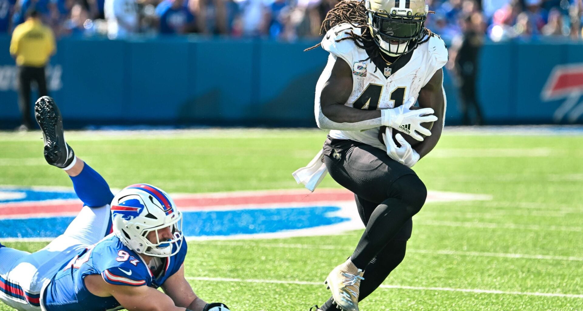 Sep 28, 2025; Orchard Park, New York, USA; New Orleans Saints running back Alvin Kamara (41) nearly fumbles after breaking a tackle by Buffalo Bills defensive end Joey Bosa (97) in the third quarter at Highmark Stadium.