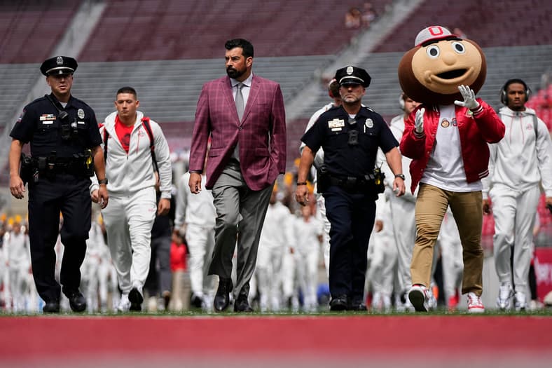 Ohio State Buckeyes head coach Ryan Day and mascot Brutus walk across the field as the team arrives prior to the NCAA footba…