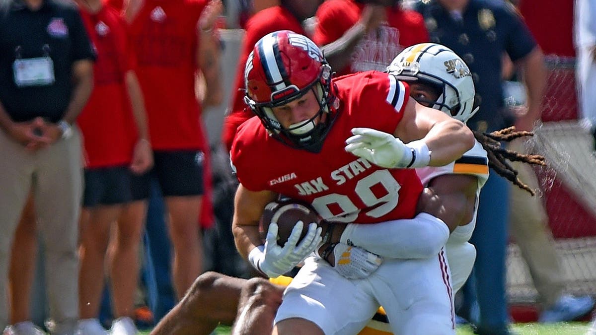 Jacksonville State's Brock Rechsteiner tries to evade tackle by Southern Miss' Dylan Lawrence on football field