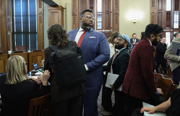State Rep. Kam Buckner, center, rises after attending a House Executive Committee hearing on the budget bill during the spring legislative session at the State Capitol, May 31, 2026, in Springfield. (John J. Kim/Chicago Tribune)