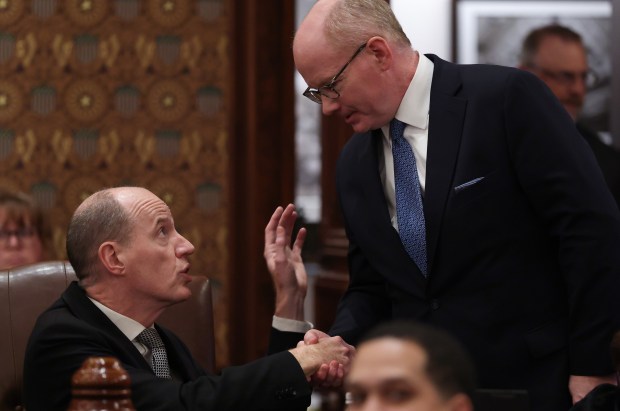 State Sen. Bill Cunningham, left, is congratulated by Illinois Senate President Don Harmon after a bill drawn up by Cunningham to have a new stadium for the Chicago Bears built in Illinois passes on the final night of the spring legislative session at the State Capitol early June 1, 2026, in Springfield. (John J. Kim/Chicago Tribune)