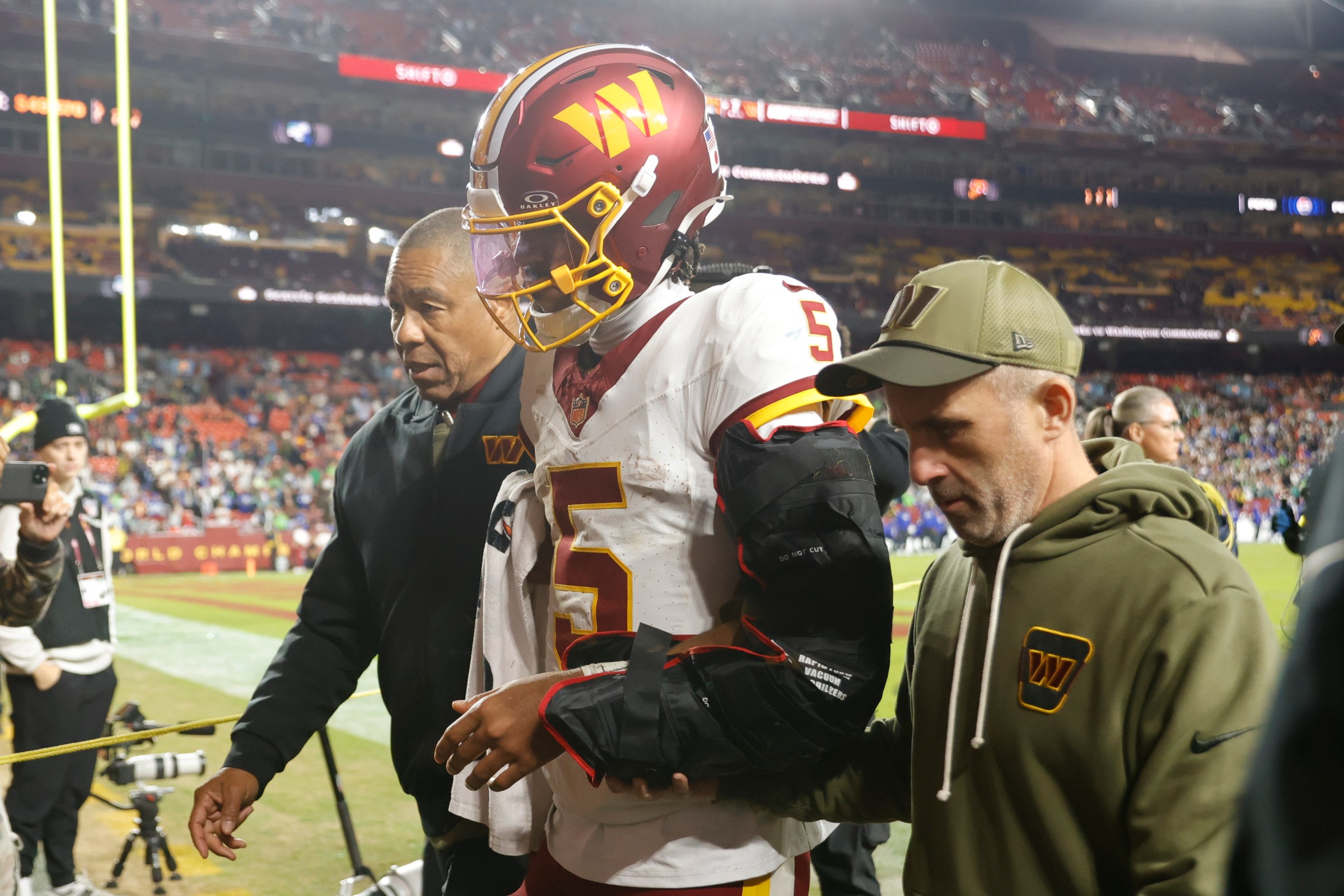 Nov 2, 2025; Landover, Maryland, USA; Washington Commanders quarterback Jayden Daniels (5) is helped off the field after an injury during the second half against the Seattle Seahawks at Northwest Stadium. Mandatory Credit: Amber Searls-Imagn Images