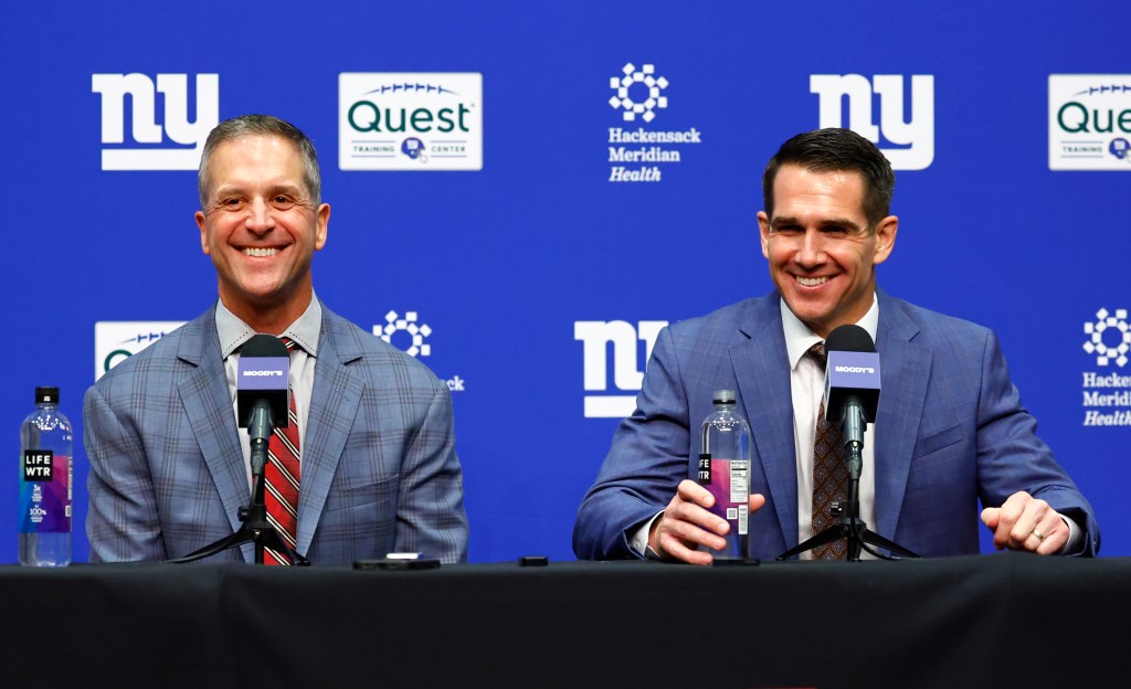 New York Giants head coach John Harbaugh and general manager Joe Schoen smiling while seated at a press conference.