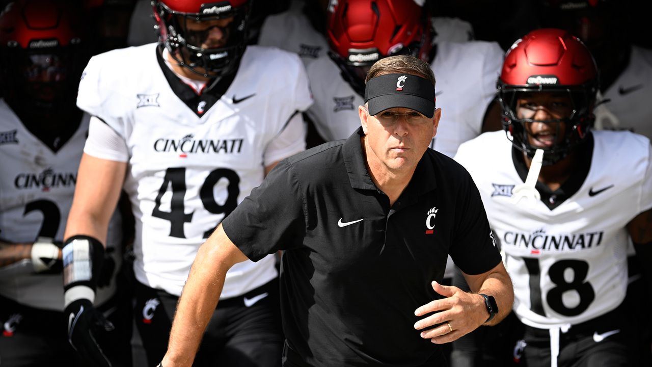 Cincinnati head coach Scott Satterfield, center, leads the team onto the field before an NCAA college football game against Central Florida, Oct. 12, 2024, in Orlando, Fla. (AP Photo/Phelan M. Ebenhack)