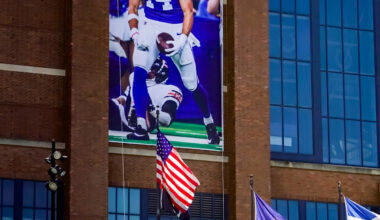 Colts players with banners (and a statue) at Lucas Oil Stadium