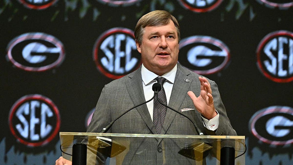Kirby Smart, head coach of the Georgia Bulldogs, speaks at a podium during a press conference.