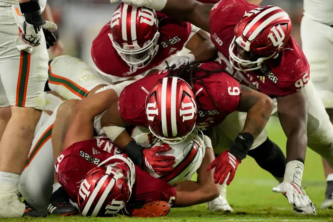 Indiana Hoosiers defenders wrap up Miami (FL) Hurricanes running back Mark Fletcher Jr. (4) on Monday, Jan. 19, 2026, during the College Football Playoff National Championship college football game at Hard Rock Stadium in Miami Gardens.