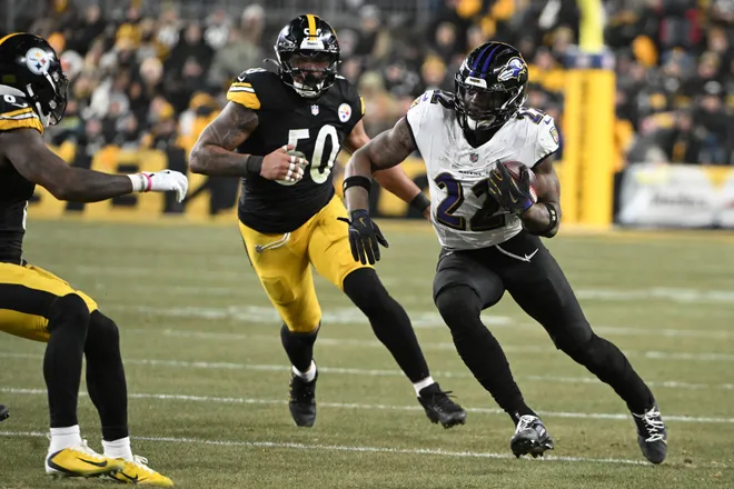 Jan 4, 2026; Pittsburgh, Pennsylvania, USA; Baltimore Ravens running back Derrick Henry (22) rushes the ball past Pittsburgh Steelers linebacker Malik Harrison (50) during the first half at Acrisure Stadium. Mandatory Credit: Barry Reeger-Imagn Images