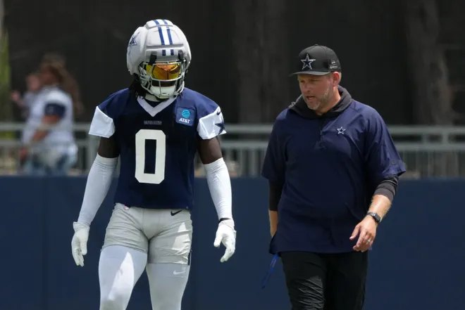 Jul 29, 2026; Oxnard, CA, USA; Dallas Cowboys linebacker DeMarvion Overshown (0) talks with inside linebackers coach Scott Symons at training camp at River Ridge Playing Fields. Mandatory Credit: Kirby Lee-Imagn Images