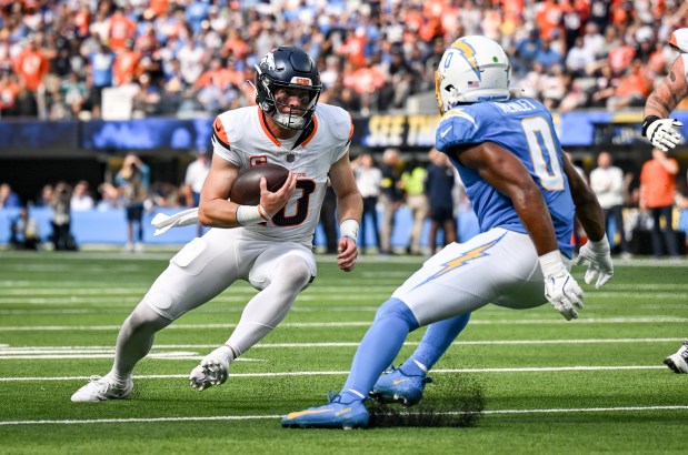 Bo Nix (10) of the Denver Broncos braces to take on Daiyan Henley (0) of the Los Angeles Chargers during the third quarter at SoFi Stadium in Inglewood, California on Sunday, Sept. 21, 2025. (Photo by AAron Ontiveroz/The Denver Post)