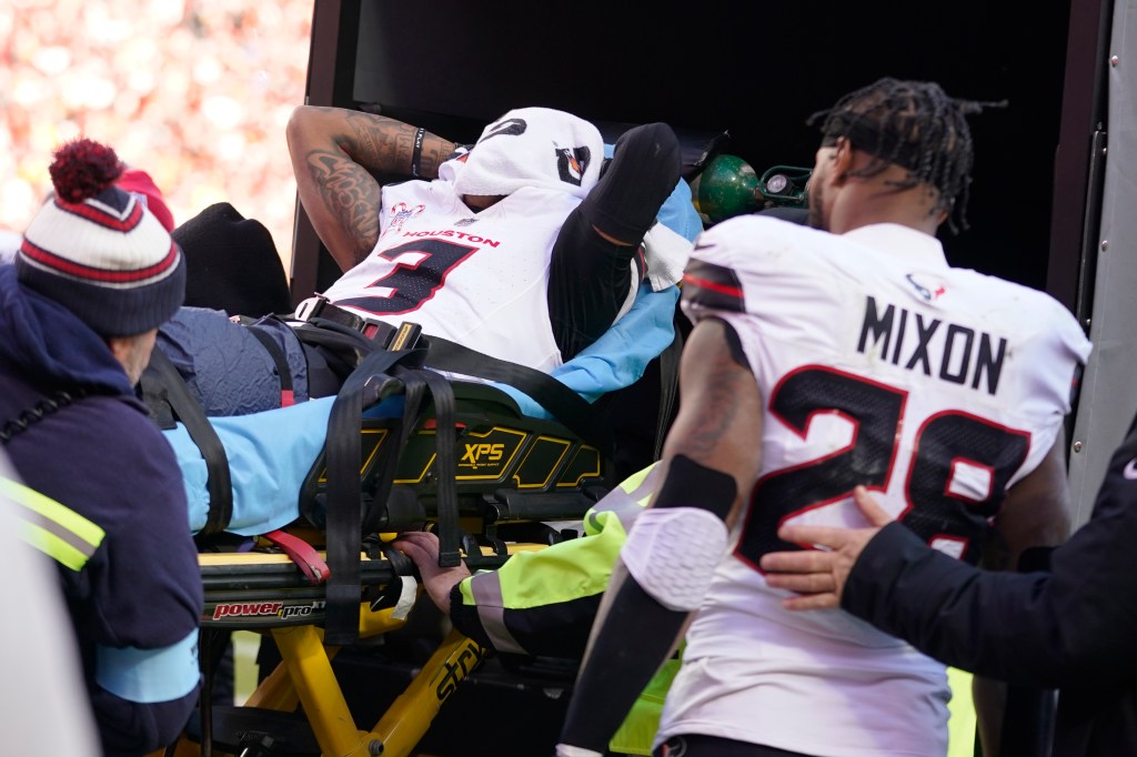 Houston Texans wide receiver Tank Dell covers his face as he is taken off the field on a stretcher after being injured while catching a touchdown pass during the second half of an NFL football game against the Kansas City Chiefs Saturday, Dec. 21, 2024, in Kansas City, Mo.