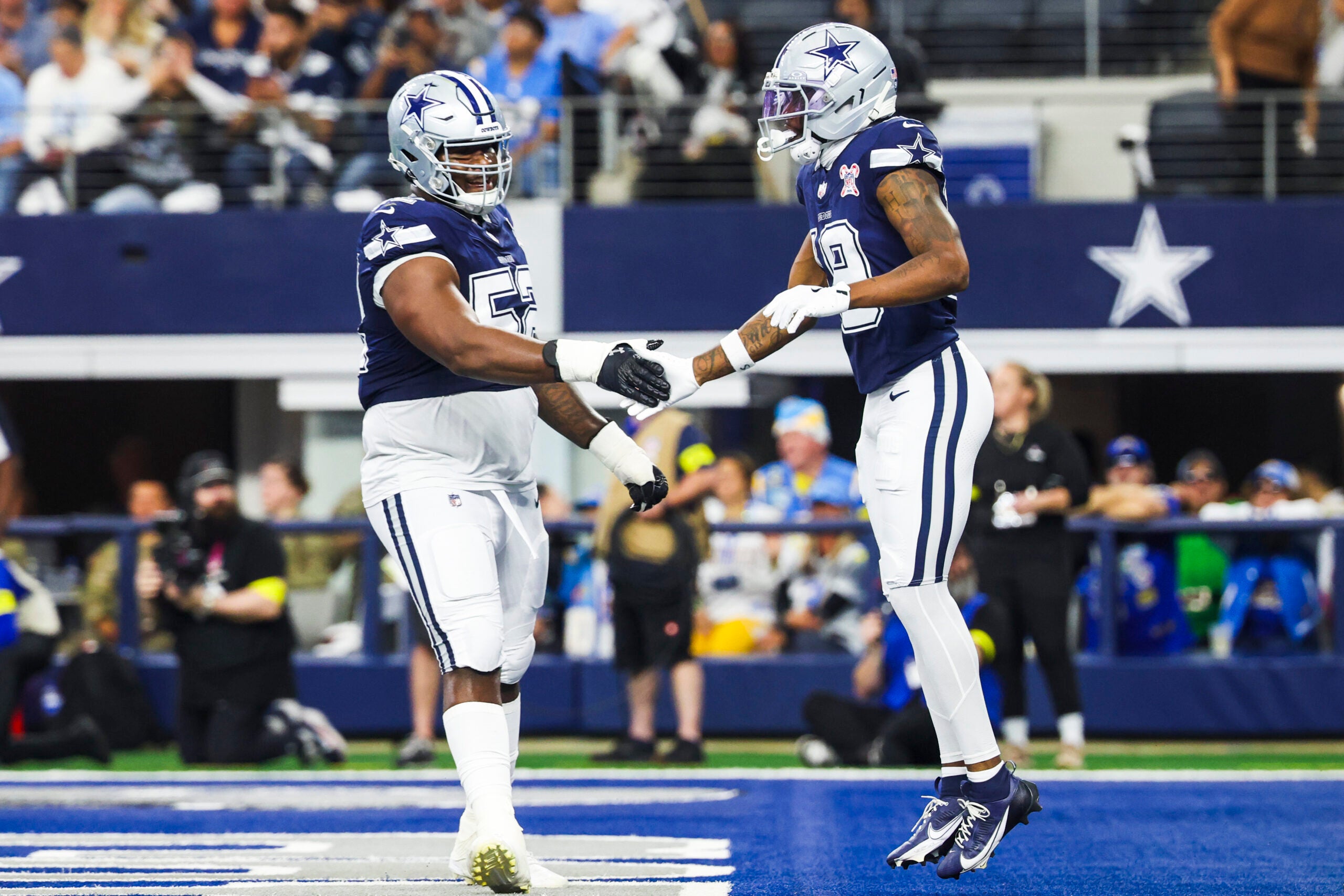 Dec 21, 2025; Arlington, Texas, USA; Dallas Cowboys wide receiver Ryan Flournoy (19) celebrates with guard Tyler Booker (52) after catching a touchdown pass against the Los Angeles Chargers during the first quarter at AT&T Stadium.