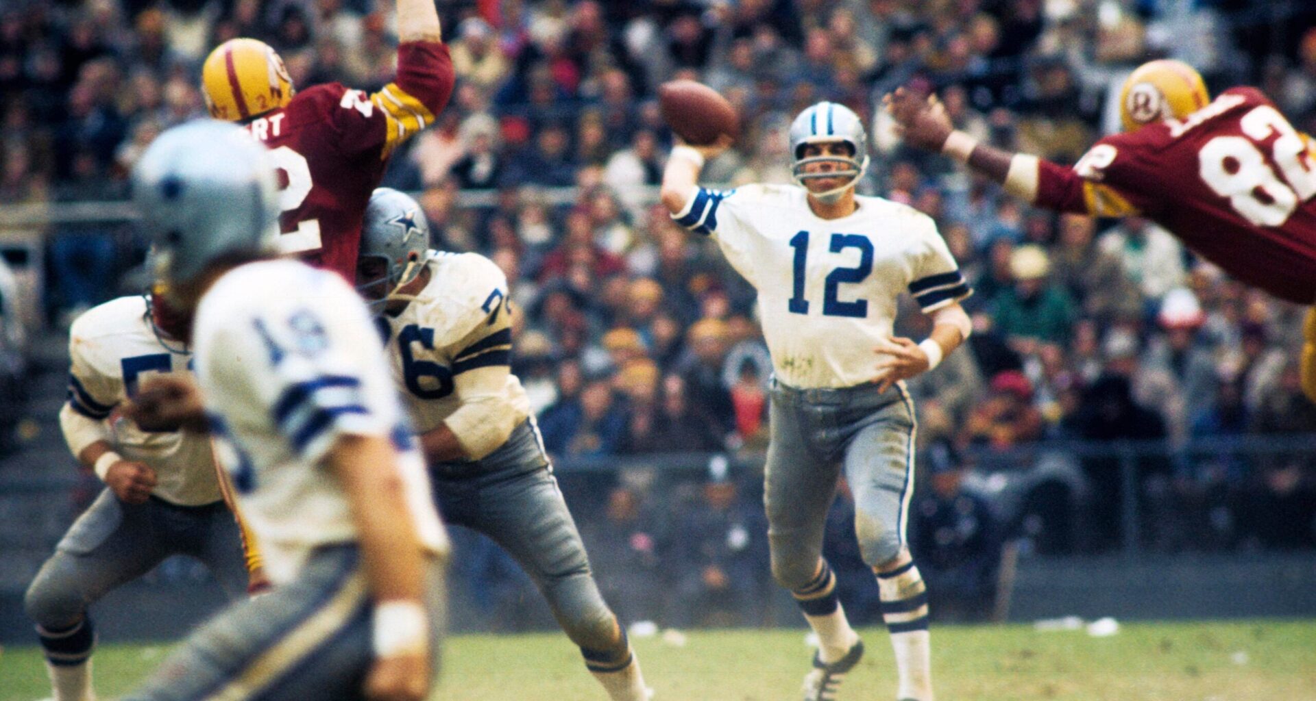 Nov 21, 1971; Washington, DC, USA; FILE PHOTO; Dallas Cowboys quarterback Roger Staubach (12) is pressured by Washington Redskins defensive end Jimmie Jones (82) at RFK Stadium.
