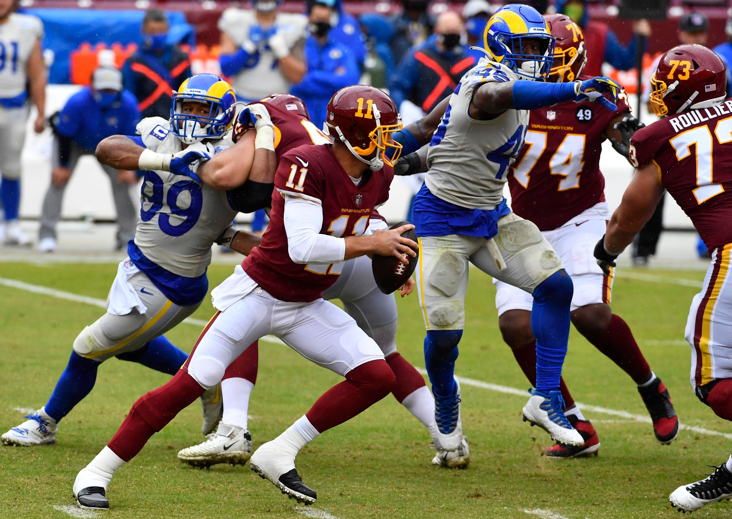 Oct 11, 2020; Landover, Maryland, USA; Washington Football Team quarterback Alex Smith (11) scrambles as Los Angeles Rams defensive end Aaron Donald (99) rushes during the second quarter at FedExField. Mandatory Credit: Brad Mills-Imagn Images