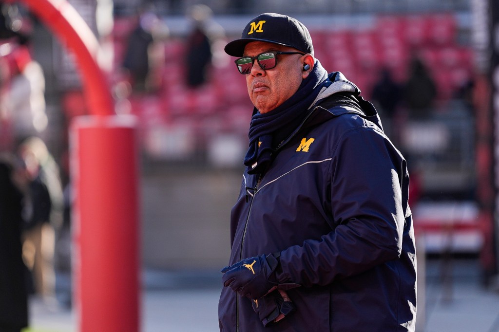 Warde Manuel, Michigan athletic director, watching warmups from the field.