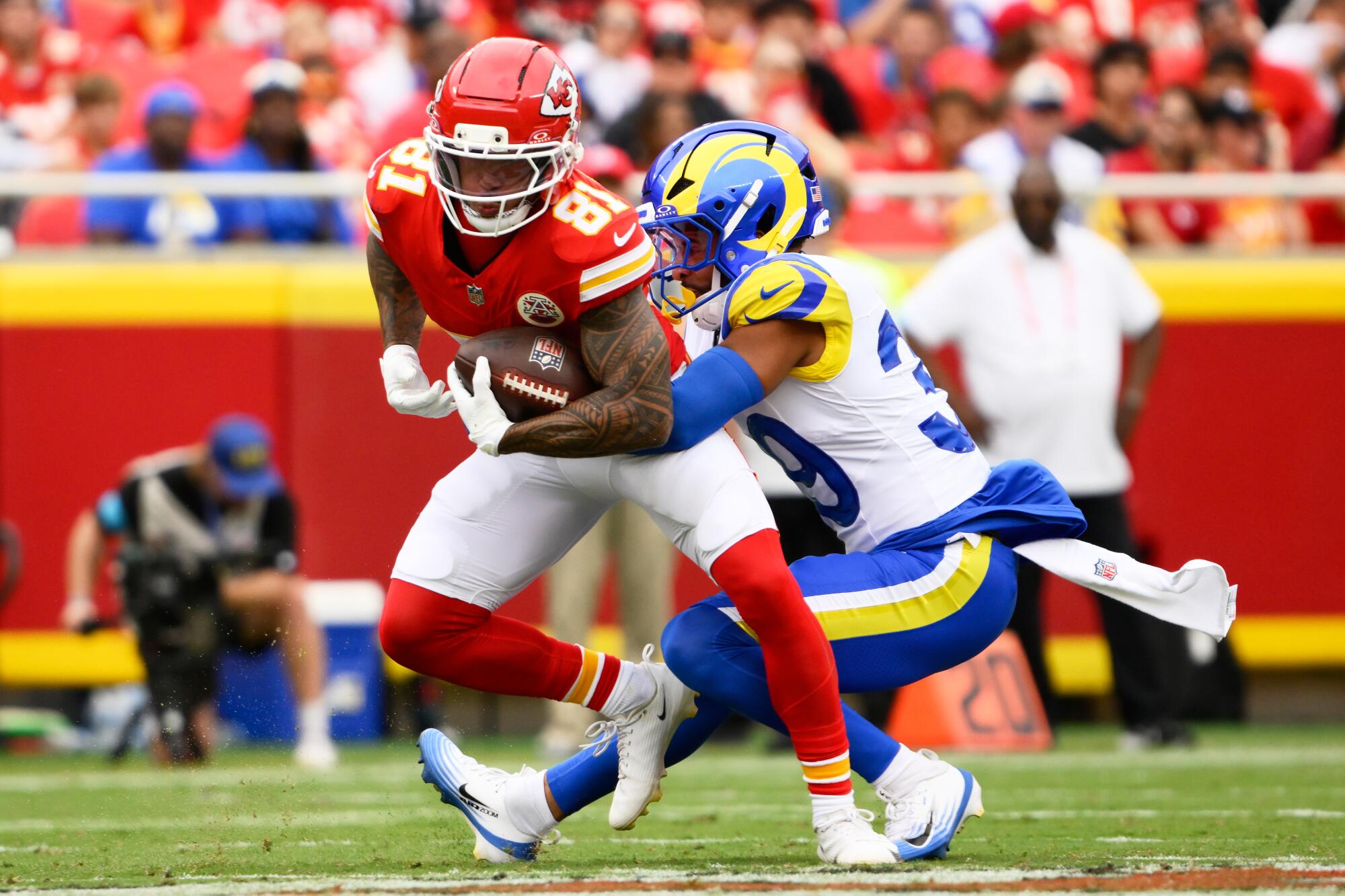 Chiefs wide receiver Nikko Remigio is tackled by Rams safety Alex Cook during the first half Saturday.