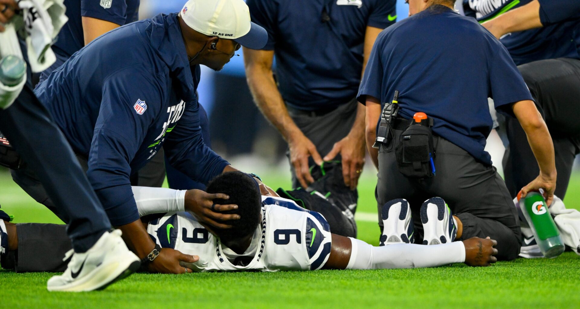 Aug 23, 2026; Nashville, Tennessee, USA; Seattle Seahawks trainer holds the ankle of safety Bud Clark (9) as they wait for the cart against the Tennessee Titans during the first half at Nissan Stadium.