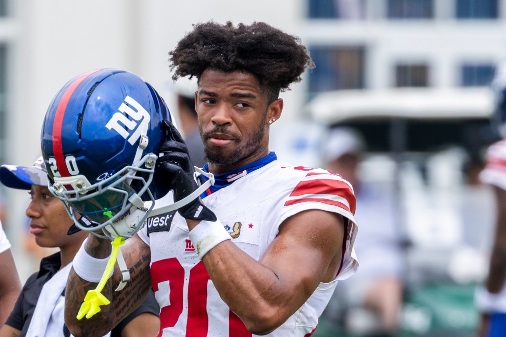 New York Giants player holds his helmet during training camp.