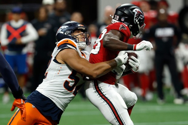 Denver Broncos linebacker Jonah Elliss (52) tackles Atlanta Falcons running back Nathan Carter (38) during the second half of a preseason NFL football game, Friday, Aug. 14, 2026, in Atlanta. (AP Photo/Erik Lesser)
