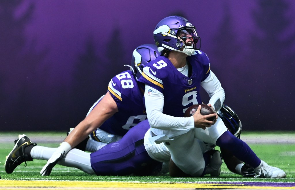J.J. McCarthy is sacked by Mike Green of the Baltimore Ravens during the first quarter of the preseason game at U.S. Bank Stadium on August 22, 2026 in Minneapolis, Minnesota.