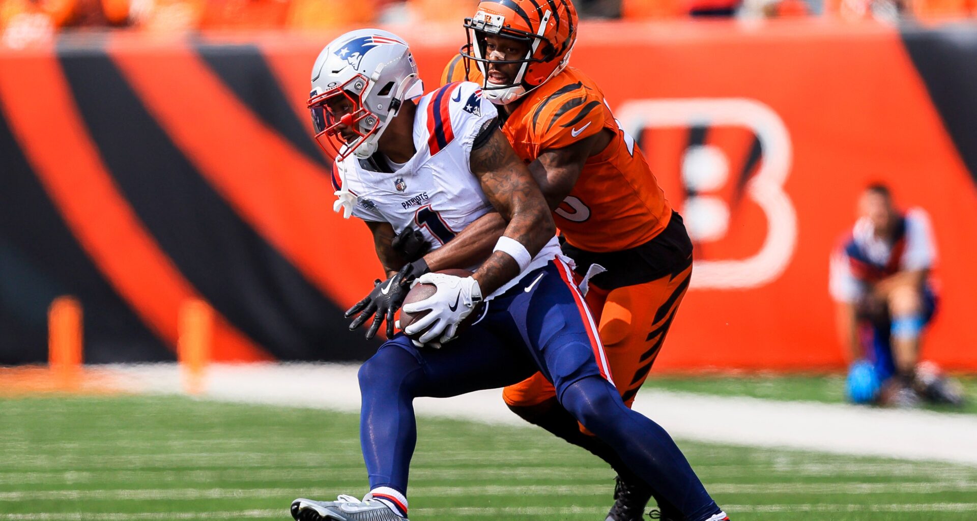 Sep 8, 2024; Cincinnati, Ohio, USA; Cincinnati Bengals cornerback Dax Hill (23) brings down New England Patriots wide receiver Ja'Lynn Polk (1) in the second half at Paycor Stadium.