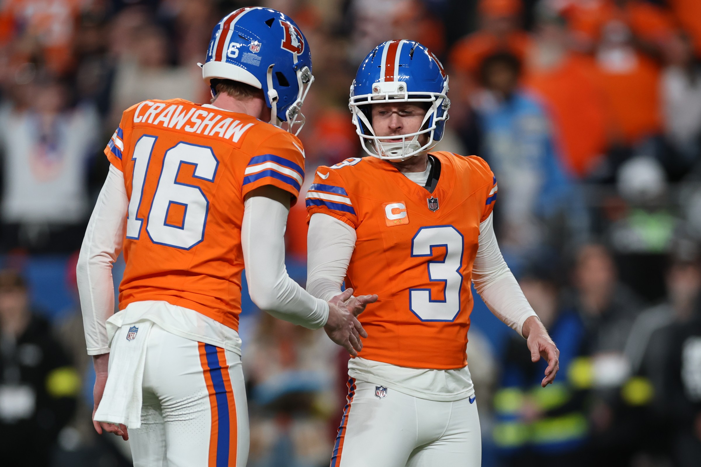 DENVER, COLORADO - JANUARY 04: Jeremy Crawshaw #16 of the Denver Broncos and Wil Lutz #3 of the Denver Broncos shake hands after a field goal in the second half at Empower Field At Mile High on January 04, 2026 in Denver, Colorado. (Photo by Matthew Stockman/Getty Images)
