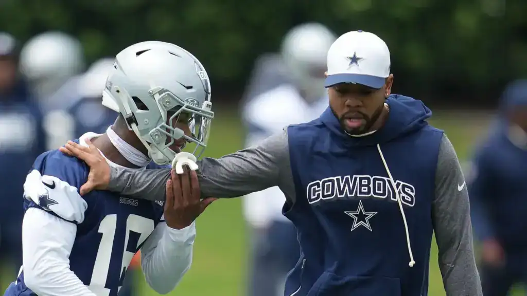 Dallas Cowboys defensive coordinator Christian Parker working with rookie safety Caleb Downs during a training camp practice. 