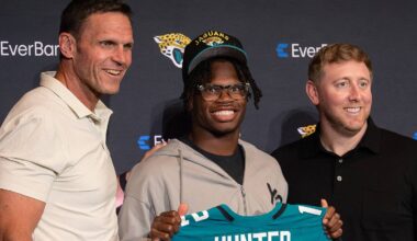 Apr 25, 2025; Jacksonville, FL, USA; Jacksonville Jaguars first round draft pick Travis Hunter poses for a photo with executive vice president of football operations Tony Boselli, head coach Liam Coen, and general manager James Gladstone, during a press conference at Miller Electric Center. Mandatory Credit: Travis Register-Imagn Images