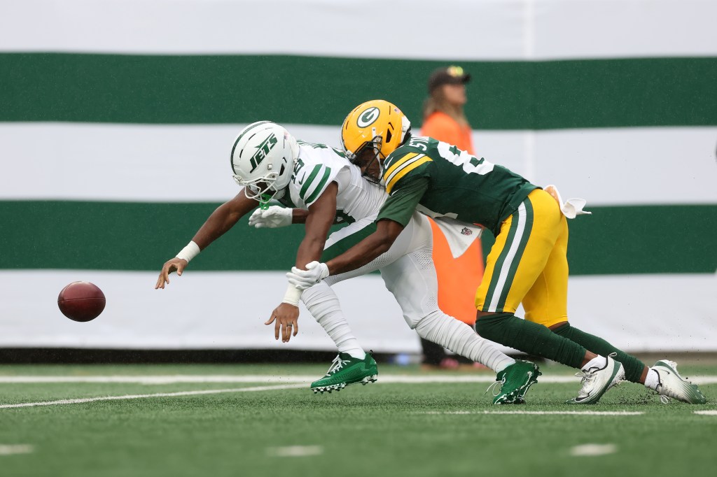 New York Jets player Isaiah Williams is tackled by Green Bay Packers player J. Michael Sturdivant, as the football falls to the ground.