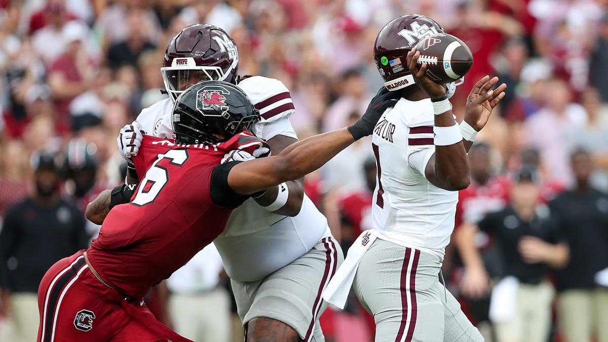 Dylan Stewart reaches for Mississippi State quarterback Kamario Taylor during a college football game.