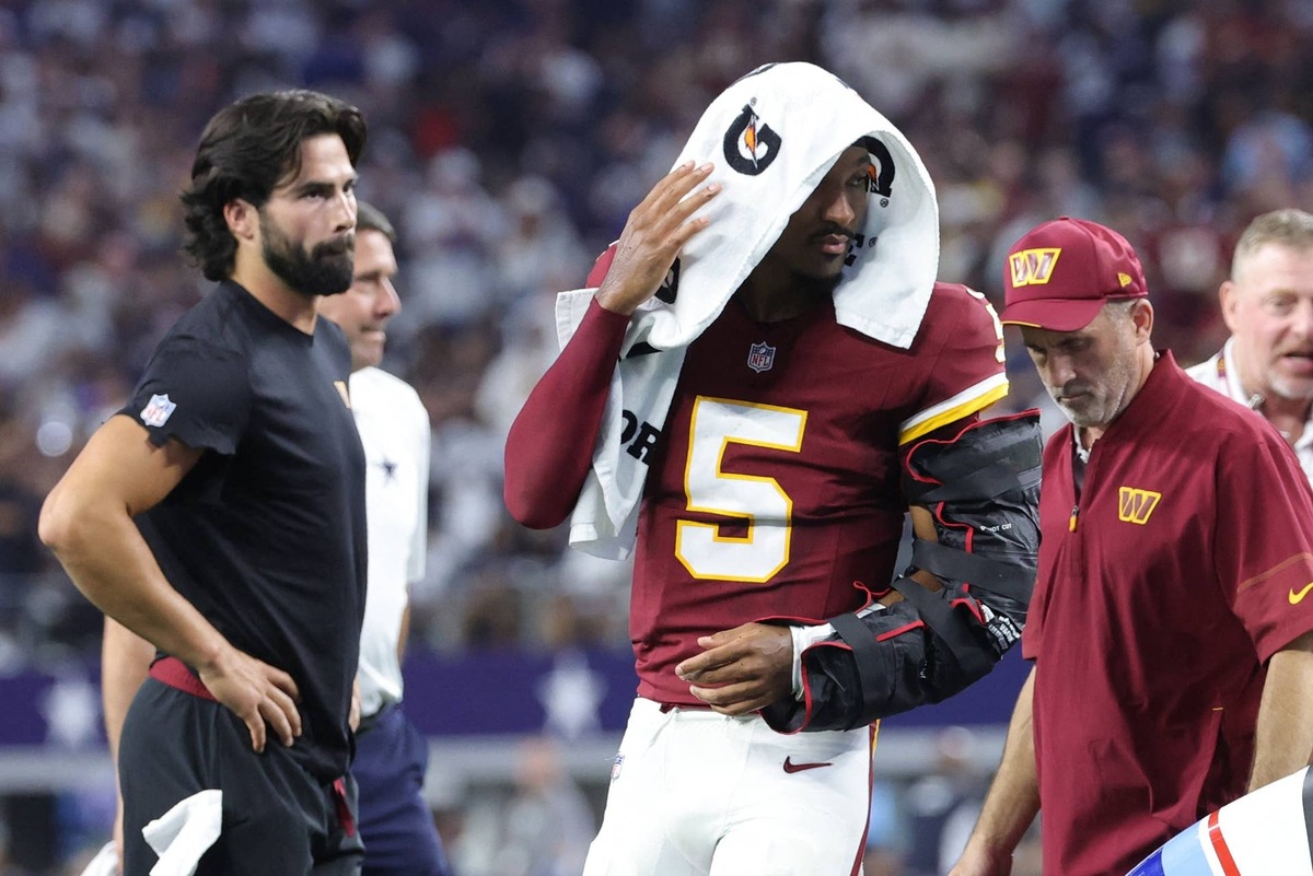  Sep 20, 2026; Arlington, Texas, USA; Washington Commanders quarterback Jayden Daniels (5) leaves the game with an apparent injury to his left arm during the second half against the Dallas Cowboys at AT&T Stadium. Mandatory Credit: Kevin Jairaj-Imagn Images
