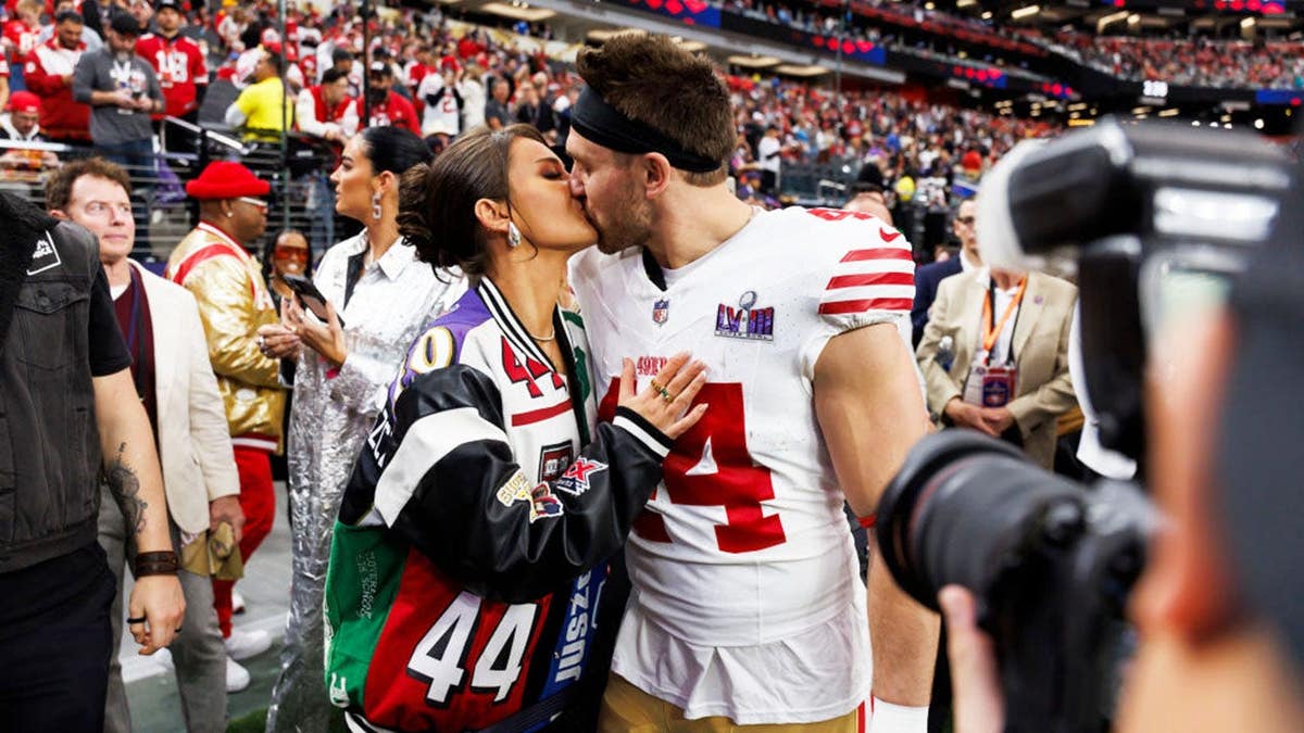 Kyle Juszczyk kisses his wife, Kristin Juszczyk, during pregame warmups.