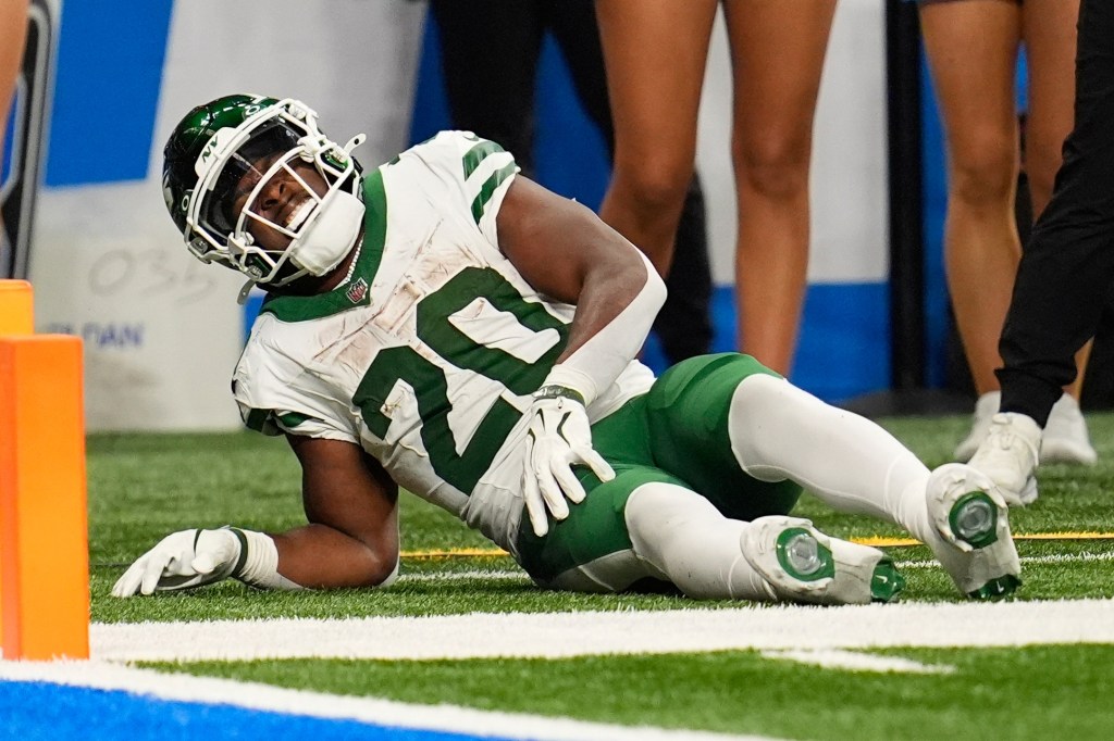 Breece Hall of the New York Jets lying injured on the field.