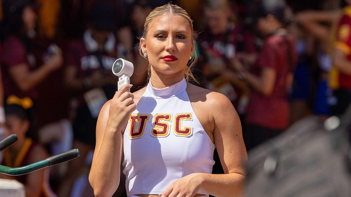 USC cheerleader holds a portable fan at the Los Angeles Memorial Coliseum.