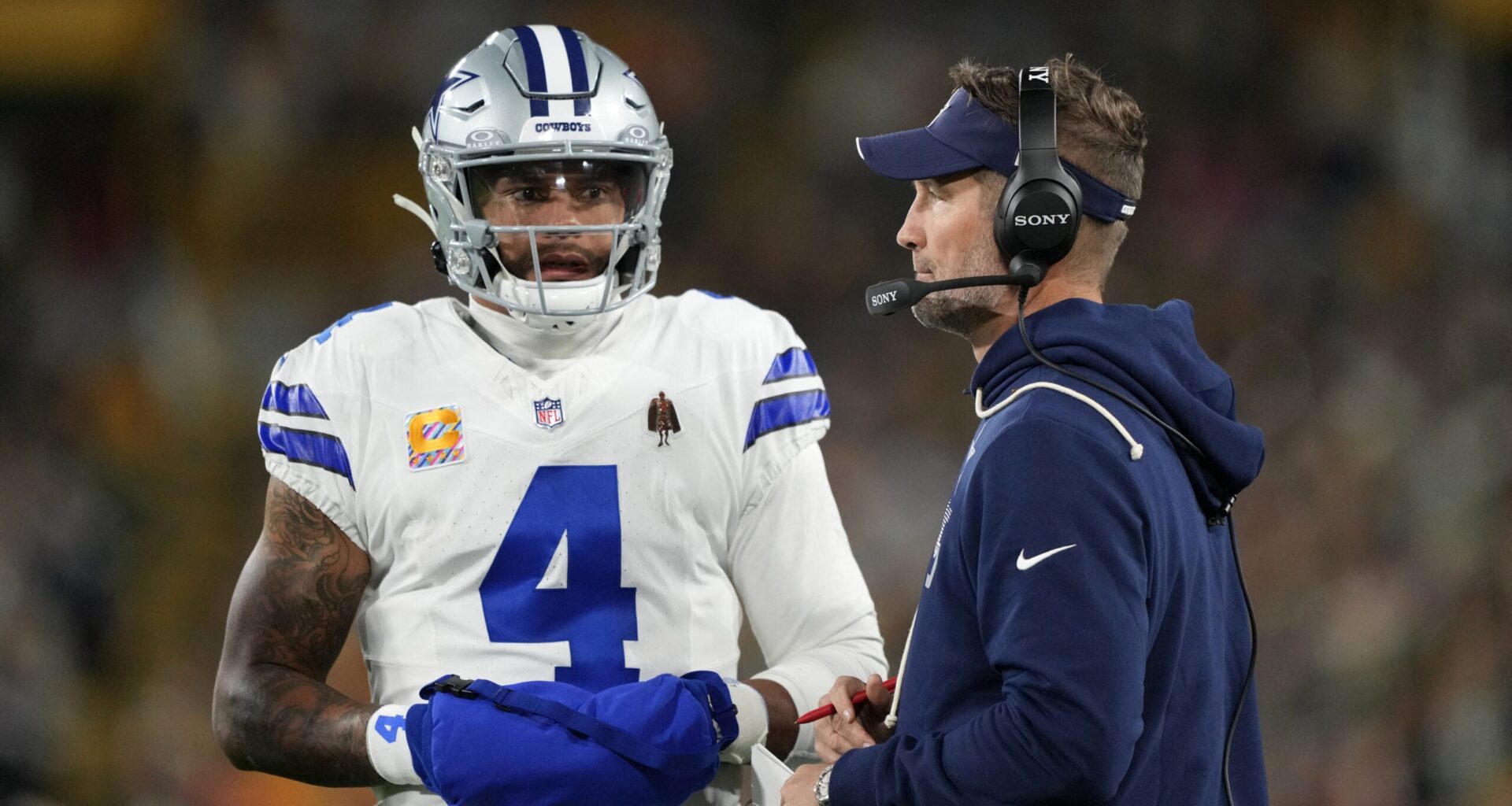 Oct 18, 2026; Green Bay, Wisconsin, USA; Dallas Cowboys quarterback Dak Prescott (4) talks with Dallas Cowboys head coach Brian Schottenheimer talk during the first quarter against the Green Bay Packers at Lambeau Field.