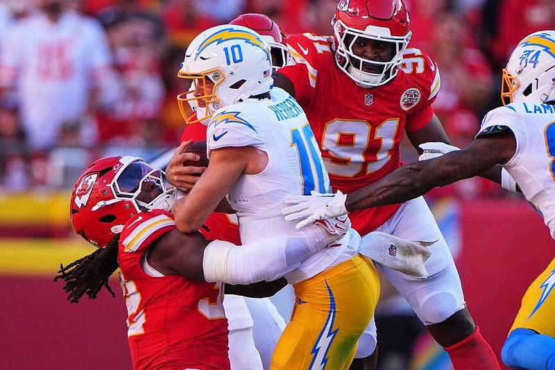 Los Angeles Chargers quarterback Justin Herbert (10) is tackled by Kansas City Chiefs linebacker Nick Bolton, left, as Herbert runs the ball during the first half of an NFL football game in Kansas City, Mo., Sunday, Oct. 18, 2026. (AP Photo/Charlie Riedel)