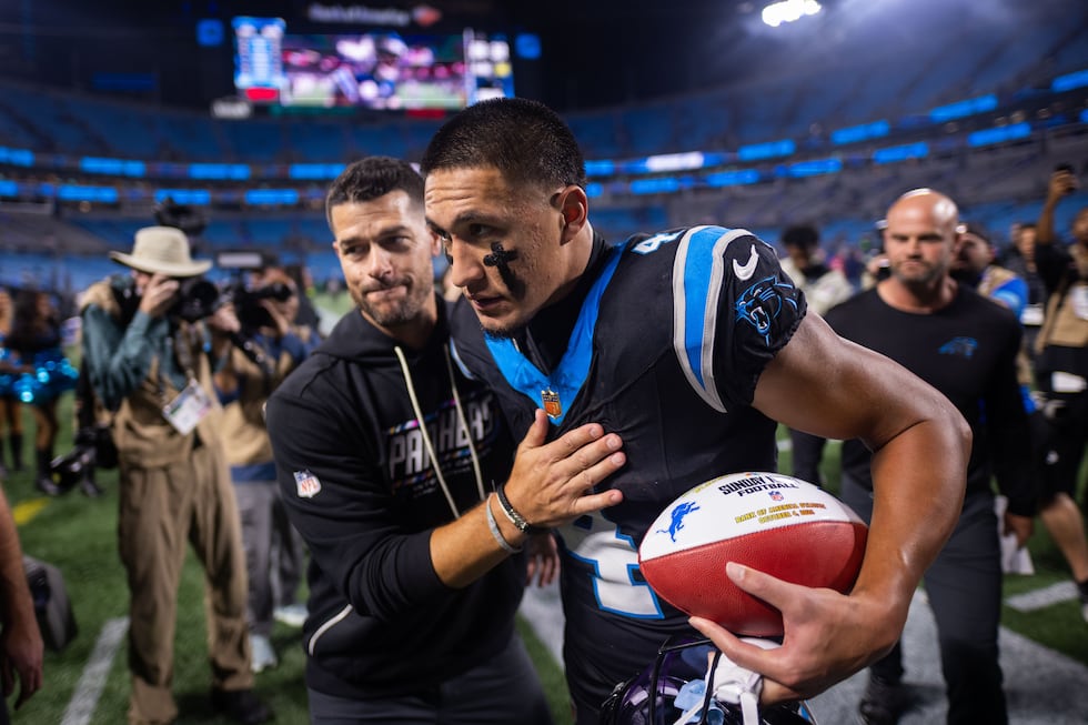 Carolina Panthers head coach Dave Canales and wide receiver Tetairoa McMillan (4) heads off...