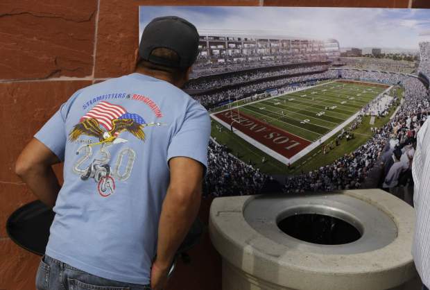 In this Feb. 19, 2015, file photo, a football fan checks a rendering for a proposed NFL football stadium by the owners of the San Diego Chargers and Oakland Raiders during a news conference in Carson, Calif. (Damian Dovarganes, The Associated Press)