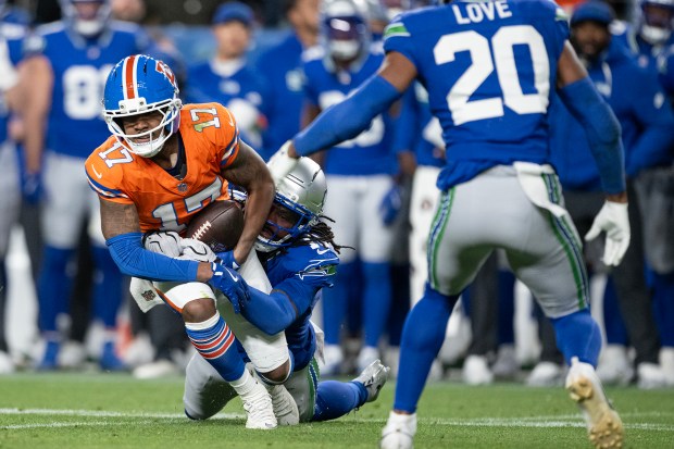 Wide receiver Jaylen Waddle (17) of the Denver Broncos pulls in a catch while being tackled by cornerback Trevon Diggs (16) of the Seattle Seahawks during second half of a 17-14 overtime Broncos win on Thursday, Oct. 15, 2026, at Empower Field at Mile High in Denver. (Photo by Timothy Hurst/The Denver Post)