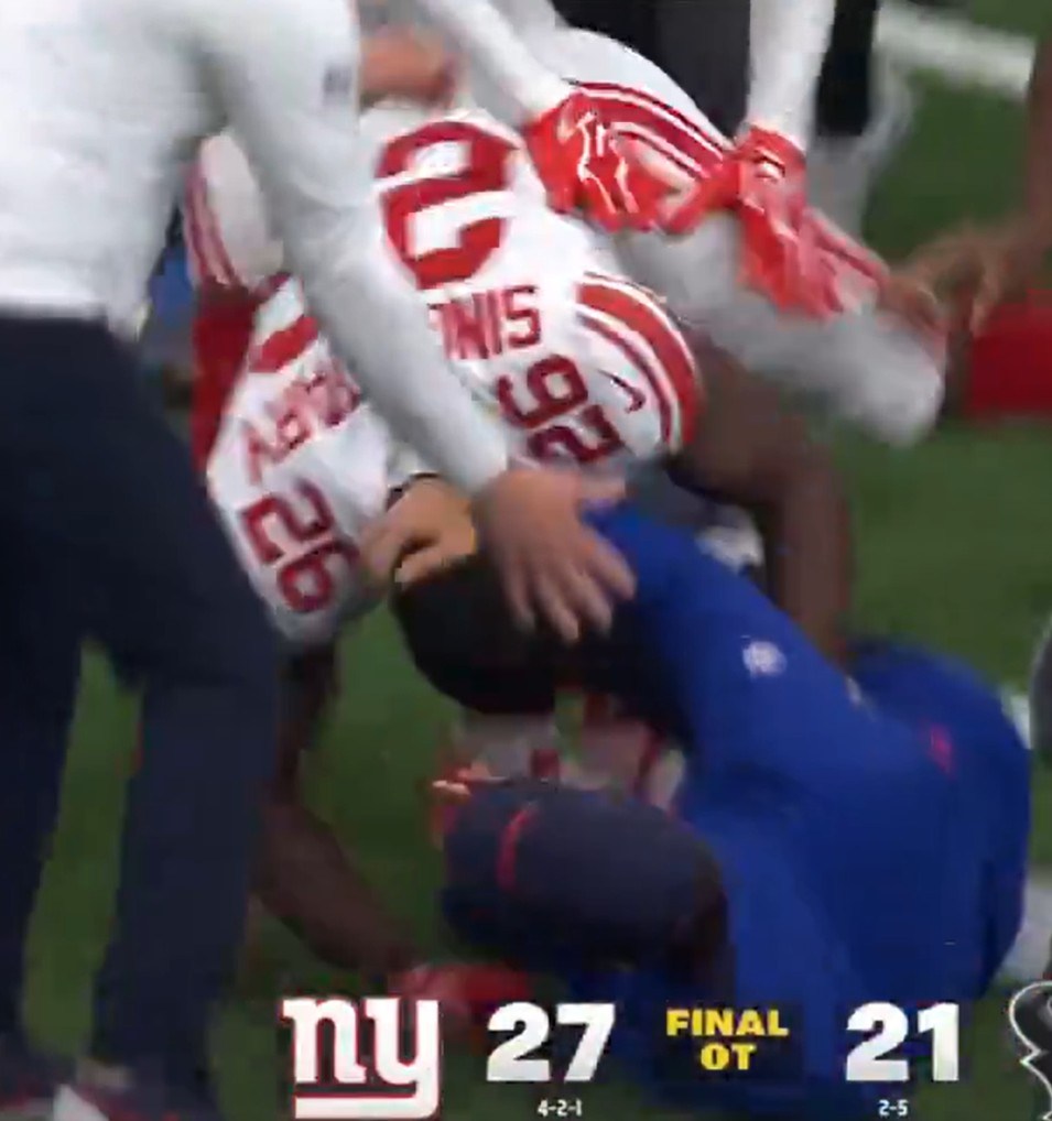 Giants running back Devin Singletary (26) tackles head coach John Harbaugh to the ground after a win over the Texans on Oct. 25, 2026.