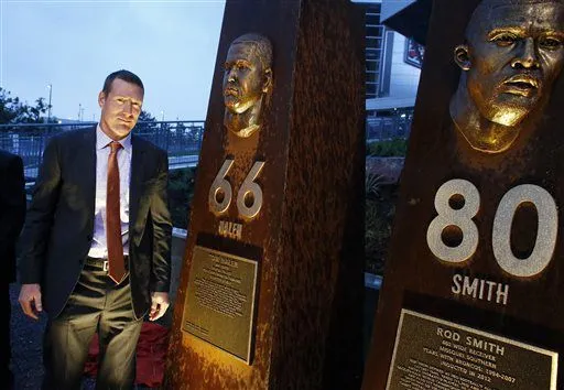 Former Denver Broncos center Tom Nalen stands in front of a pillar bearing his likeness, alongside those for fellow Bronco greats, at the unveiling ceremony for the Broncos Ring of Fame Plaza, at Mile High Stadium on Friday Sept. 27, 2013, in Denver. Nalen is to be inducted into Ring of Fame this weekend. (AP Photo/Brennan Linsley)