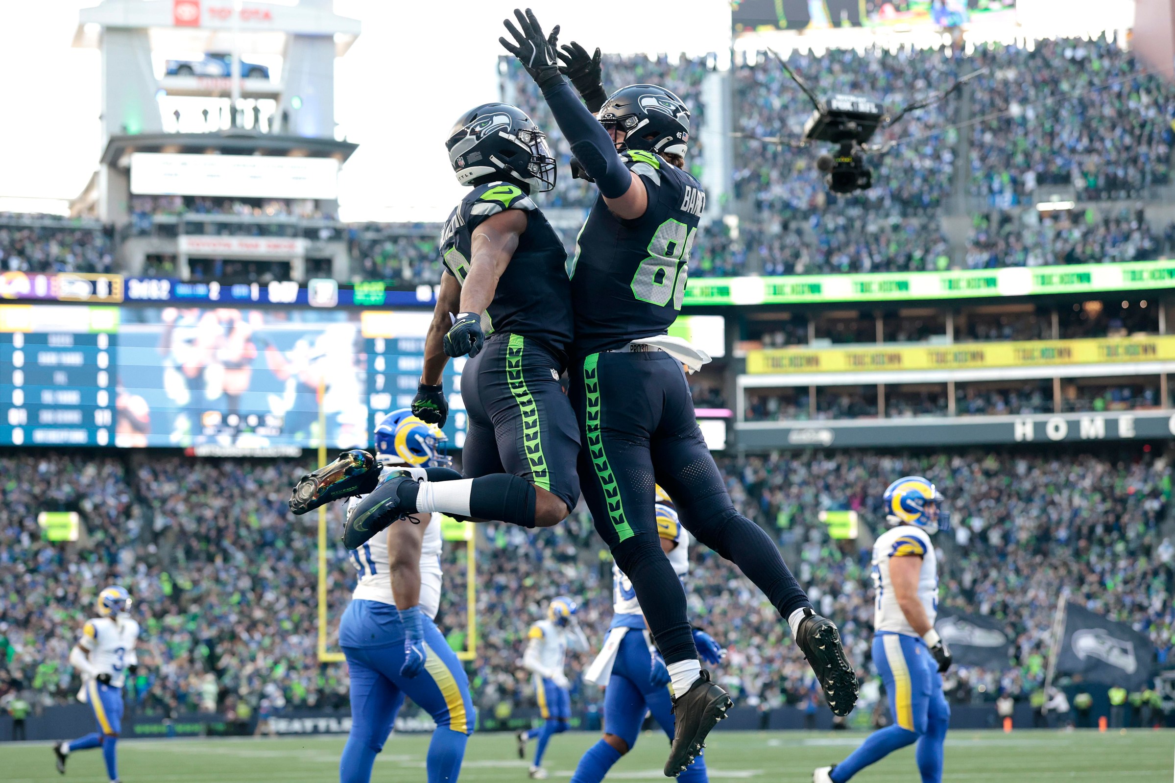 SEATTLE, WASHINGTON - JANUARY 25: Kenneth Walker III #9 celebrates with AJ Barner #88 of the Seattle Seahawks after Walker III scored a first quarter touchdown against the Los Angeles Rams in the NFC Championship game at Lumen Field on January 25, 2026 in Seattle, Washington. (Photo by Ronald Martinez/Getty Images)