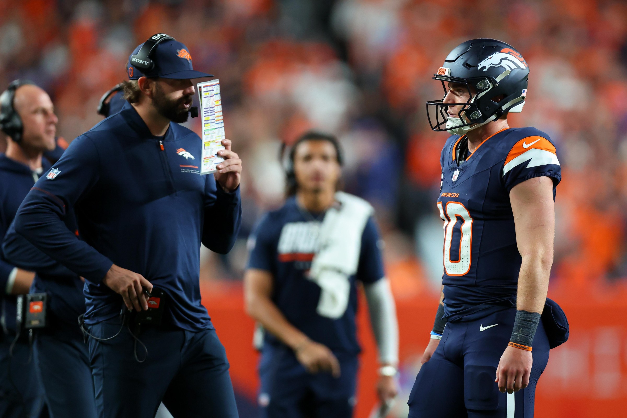 DENVER, CO - SEPTEMBER 27: Offensive coordinator Davis Webb of the Denver Broncos calls in a play as Bo Nix #10 of the Denver Broncos looks on during the fourth quarter against the Los Angeles Rams at Empower Field at Mile High on September 27, 2026 in Denver, Colorado. (Photo by Justin Edmonds/Getty Images)